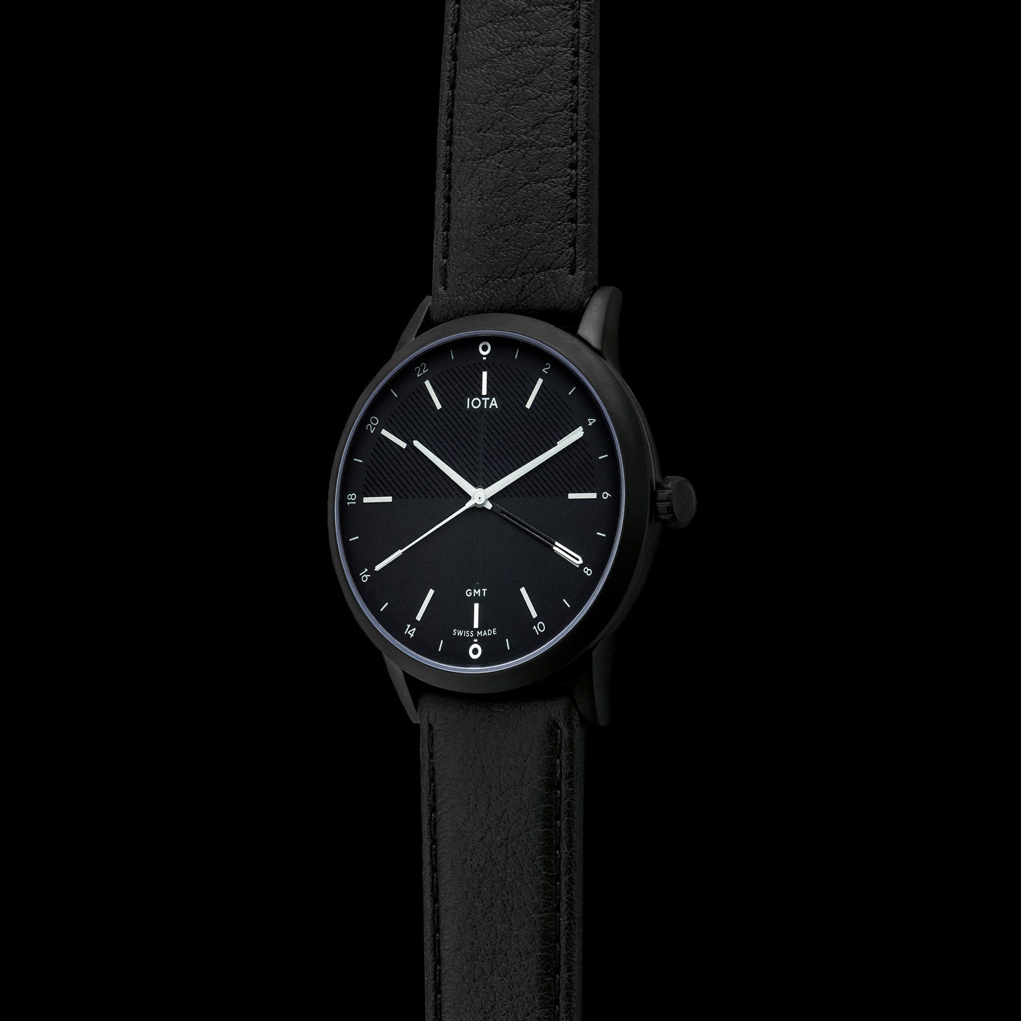 A side profile of the IOTA Hong Kong GMT watch, with black dial, black DLC coated 316L stainless steel case, housing a black French calf skin leather watch strap